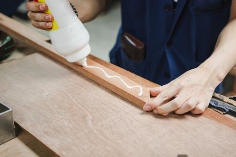 Applying wood glue to a wooden board for a woodworking project