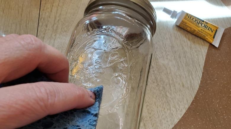 Removing dried super glue from a glass surface with a soft cloth